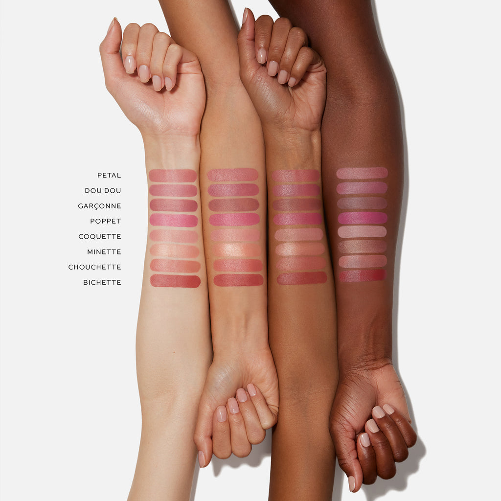 Four arms of varying skin tones showcasing swatches of Westman Atelier Baby Cheeks Blush Stick shades with buildable color, each labeled next to the corresponding swatch.