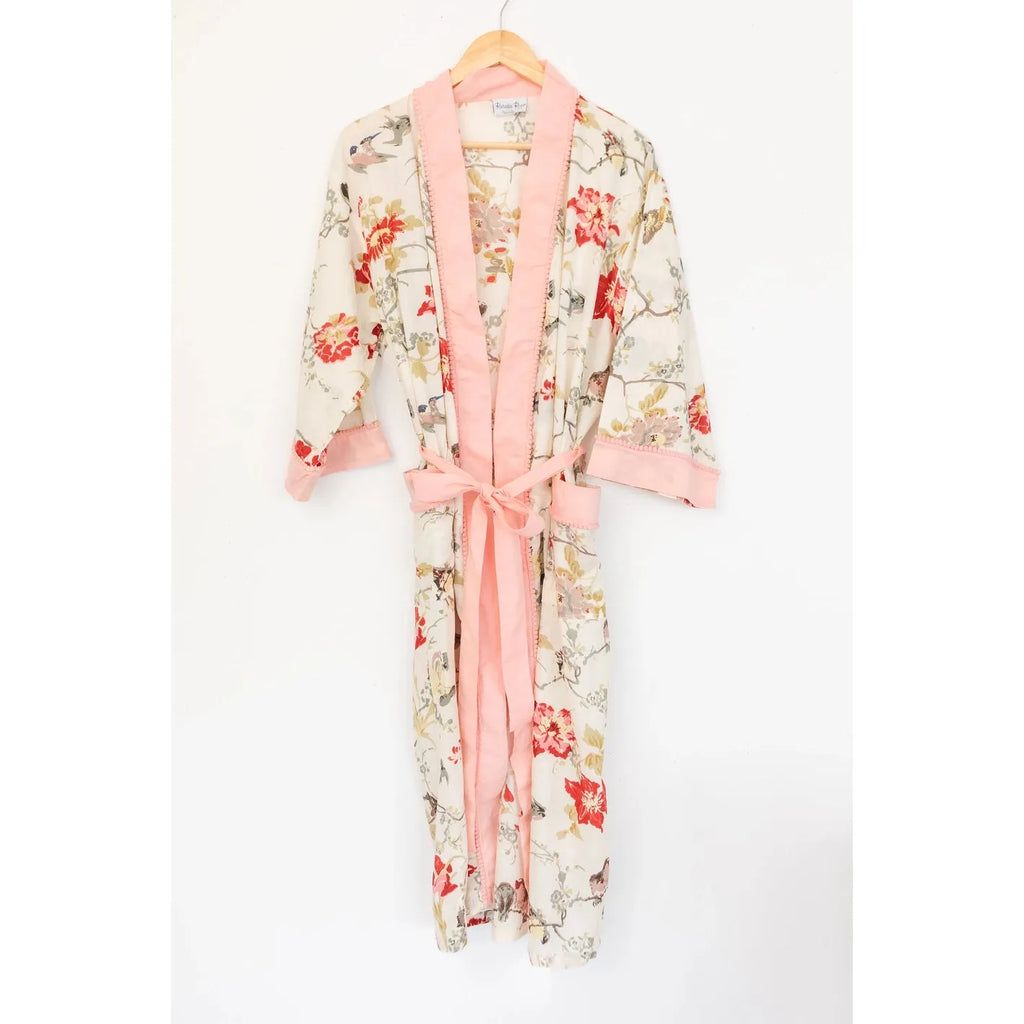 Floral print robe with a pink trim and sash hanging on a wall hook.