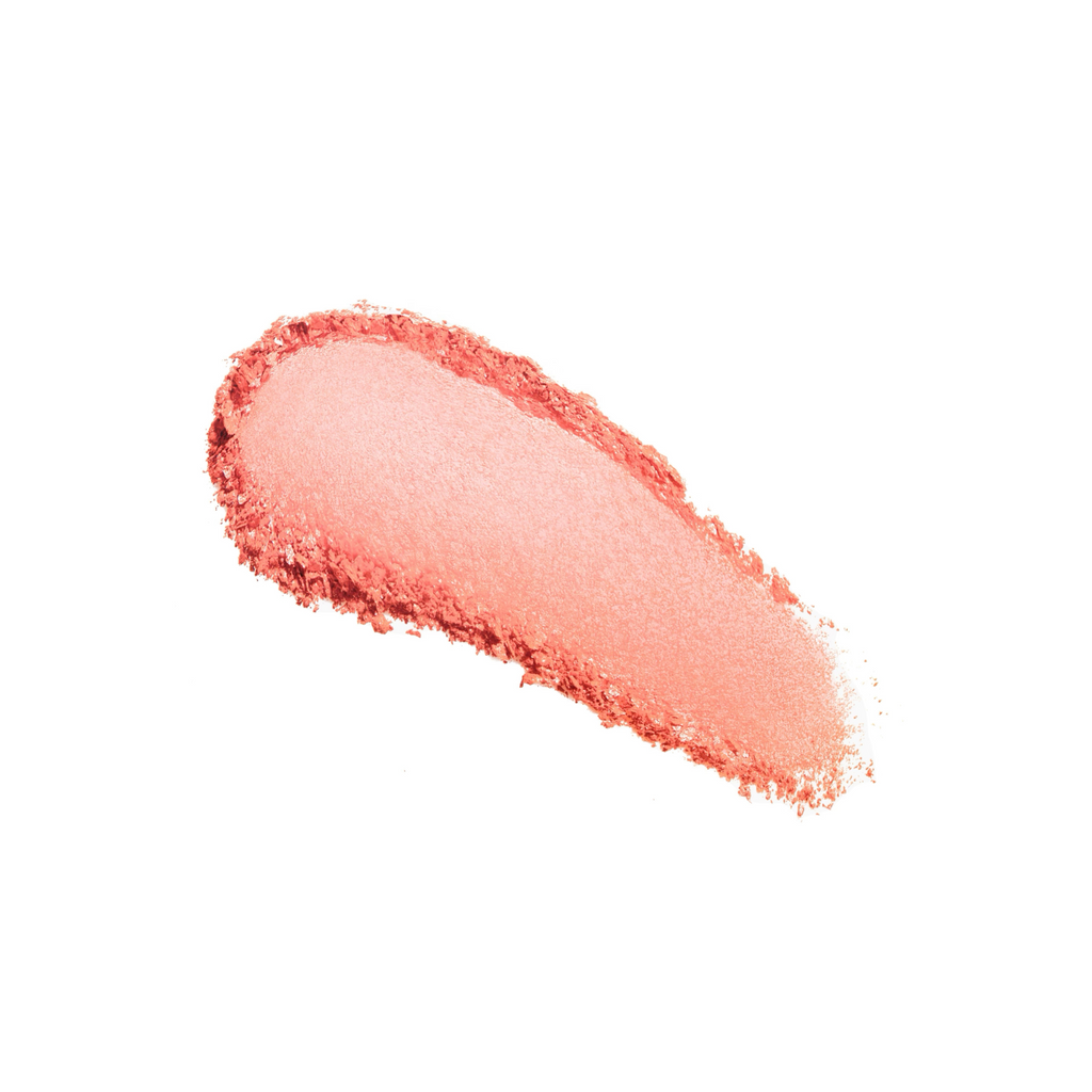 A smudged stroke of coral lipstick on a white background.