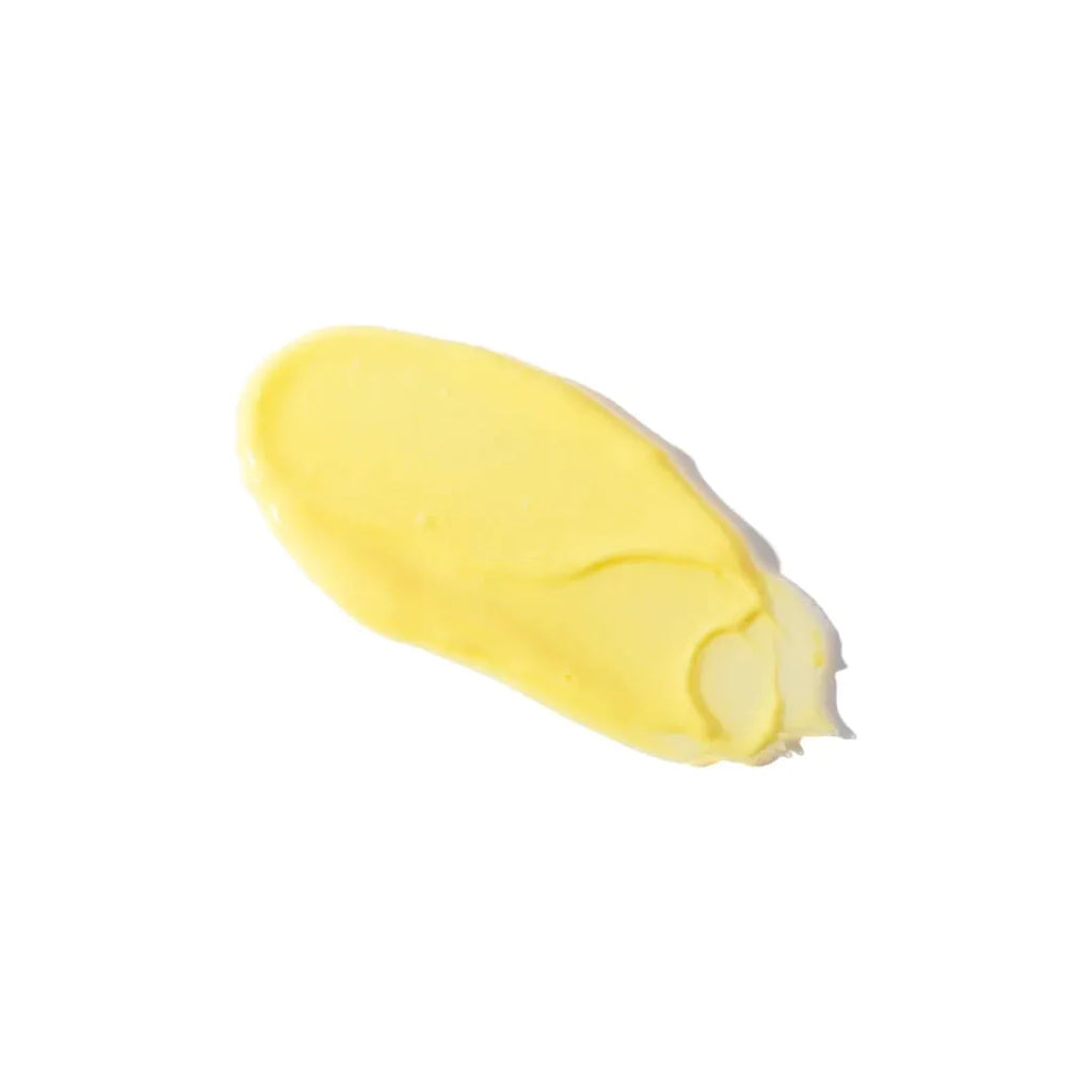 A dollop of yellow cream or paste smeared against a white background.