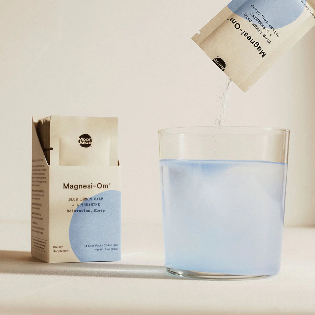 A packet labeled "magnesi-om" being poured into a glass of water.