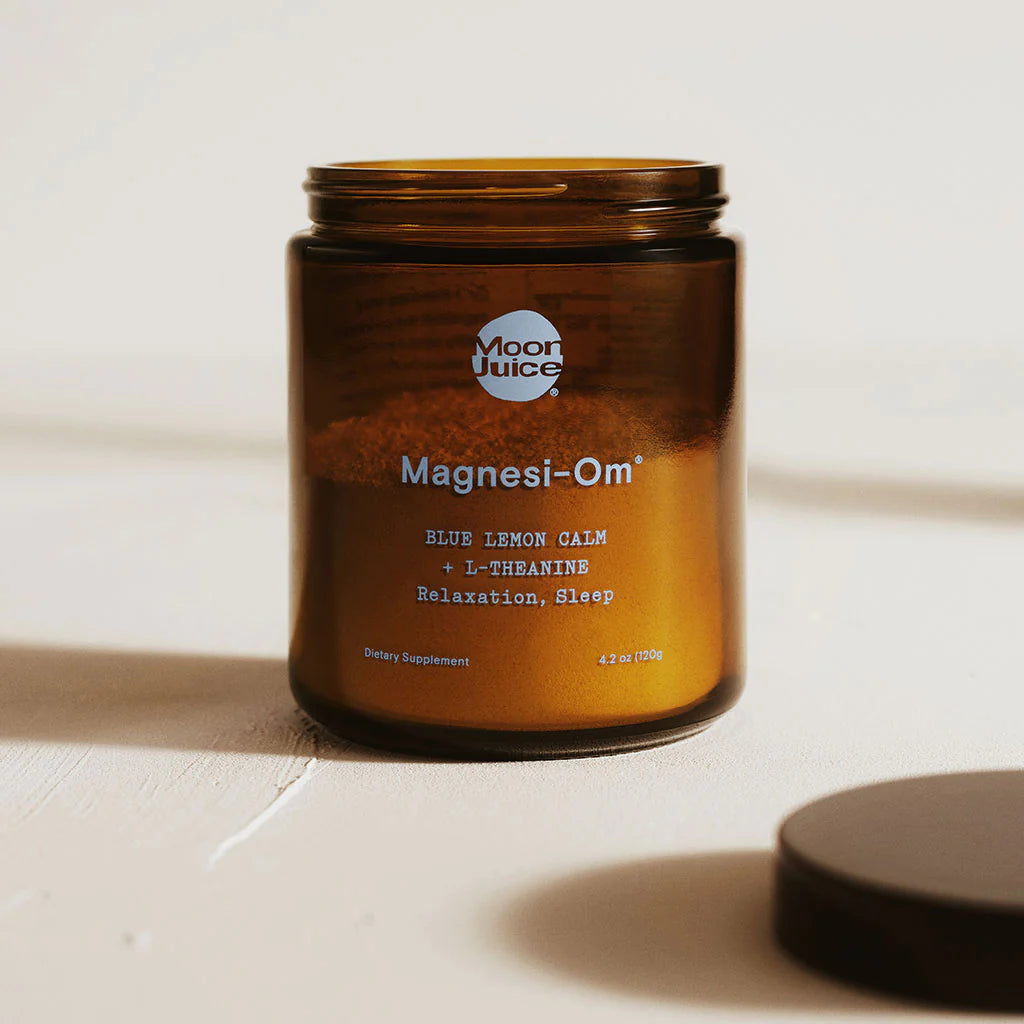 A jar of dietary supplement labeled "magnesi-om blue lemon calm with l-theanine" for relaxation and sleep.