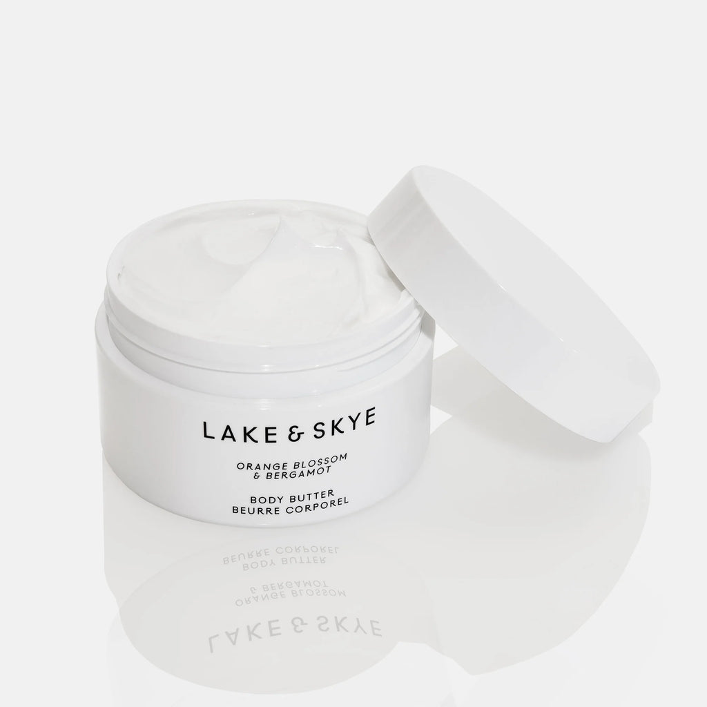 Jar of lake & skye orange blossom & bergamot body butter with the lid off, showing the product inside.