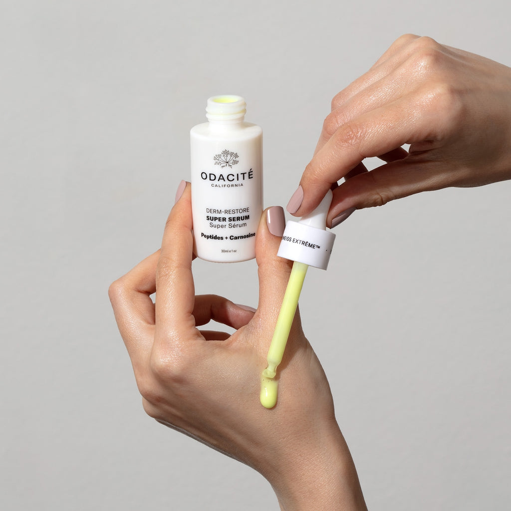 Model holding Derm Restore and dropping product with dropper on hand