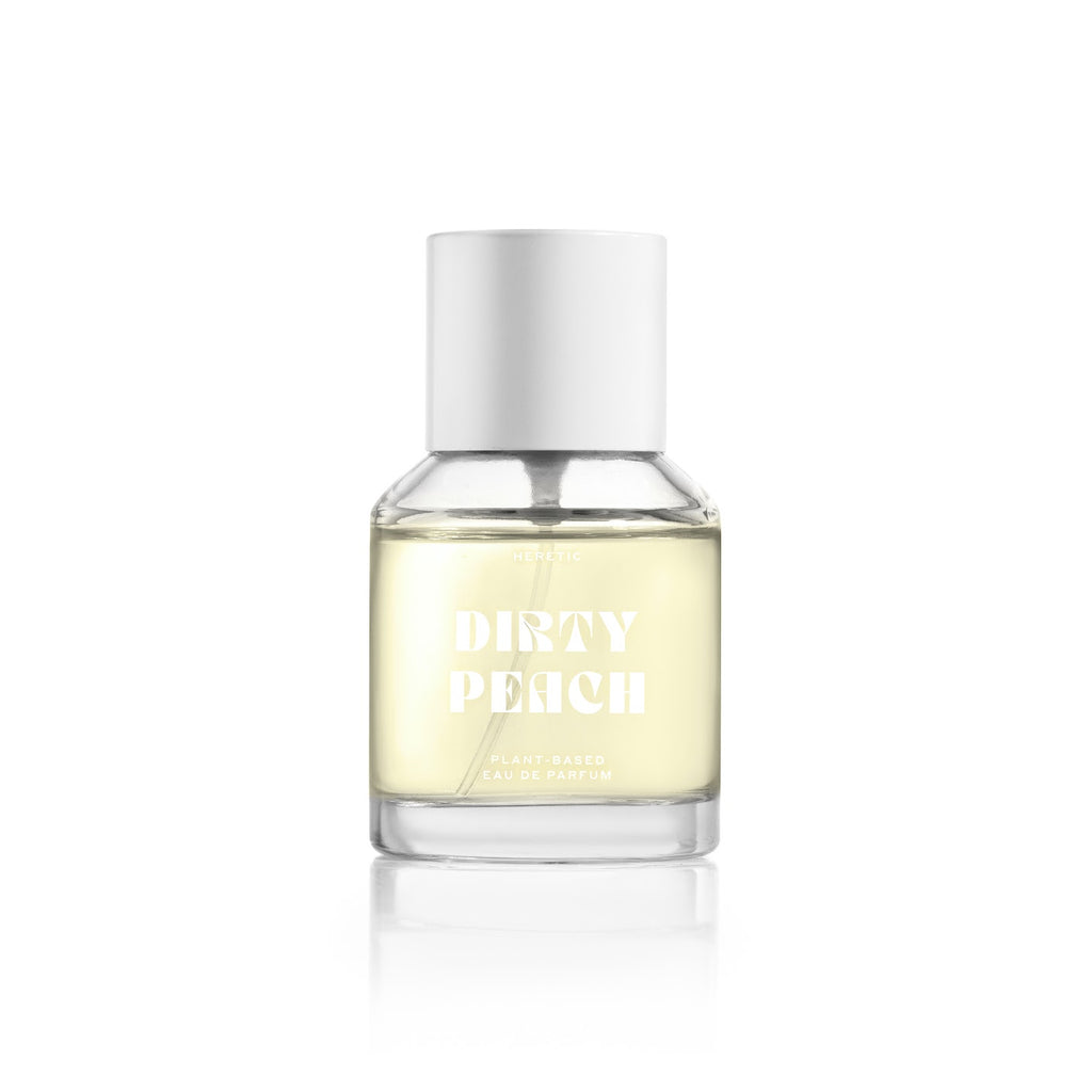 A bottle of dirty peach plant-based eau de parfum against a white background.