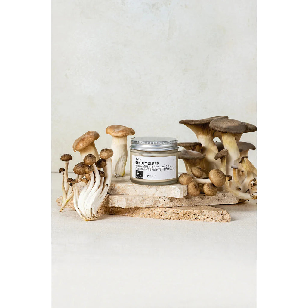 A variety of mushrooms displayed next to a "beauty sleep" beauty product on a neutral background.