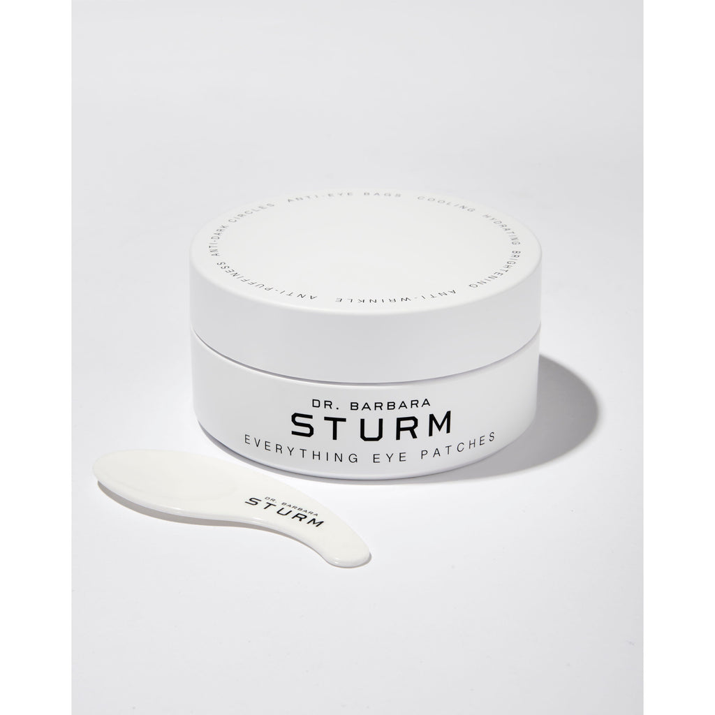 Jar of dr. barbara sturm eye patches with an applicator spoon on a white background.