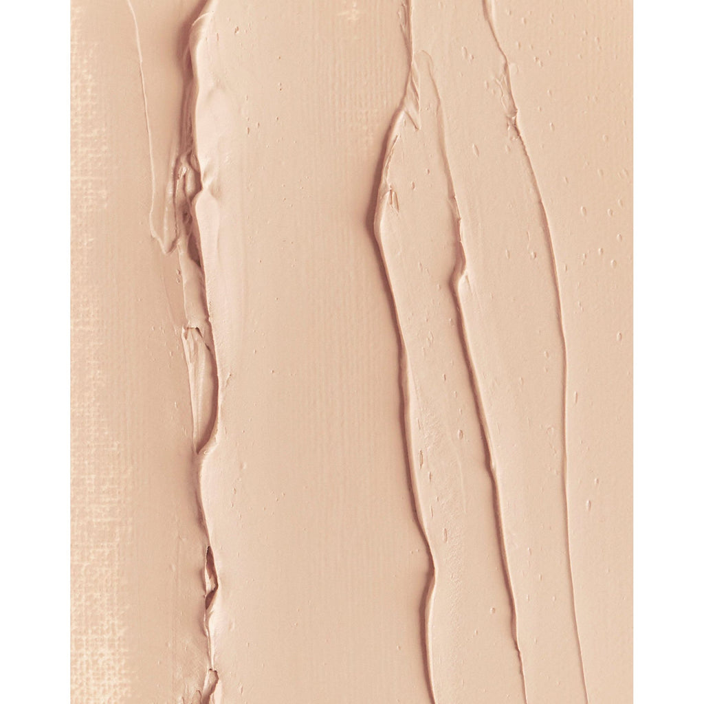 Close-up of a creamy beige substance with streaks and texture, similar to makeup foundation smeared on a surface.