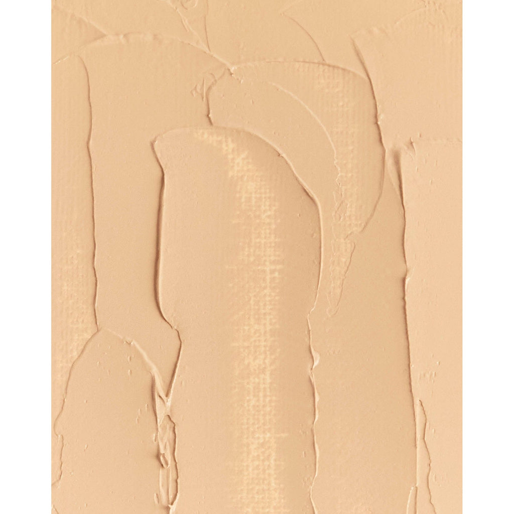 Close-up of beige foundation makeup smeared on a surface.