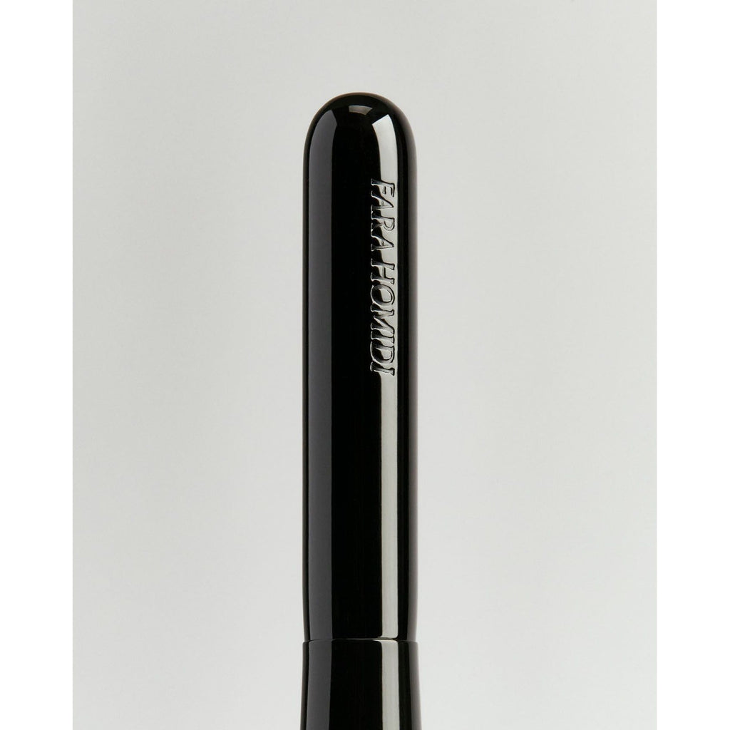 Black mascara tube with the word "paradise" printed on it against a light background.