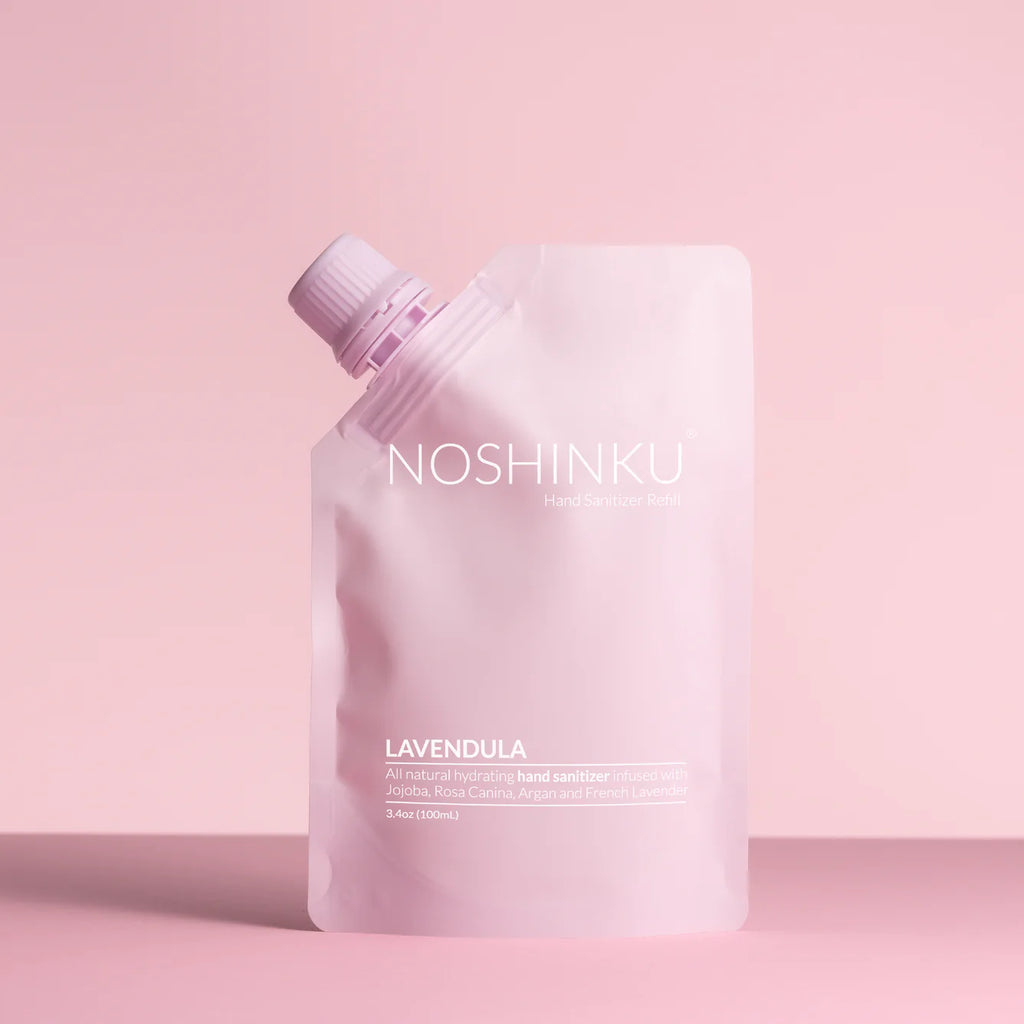 A noshinku hand sanitizer refill pouch with a lavender scent on a pink background.
