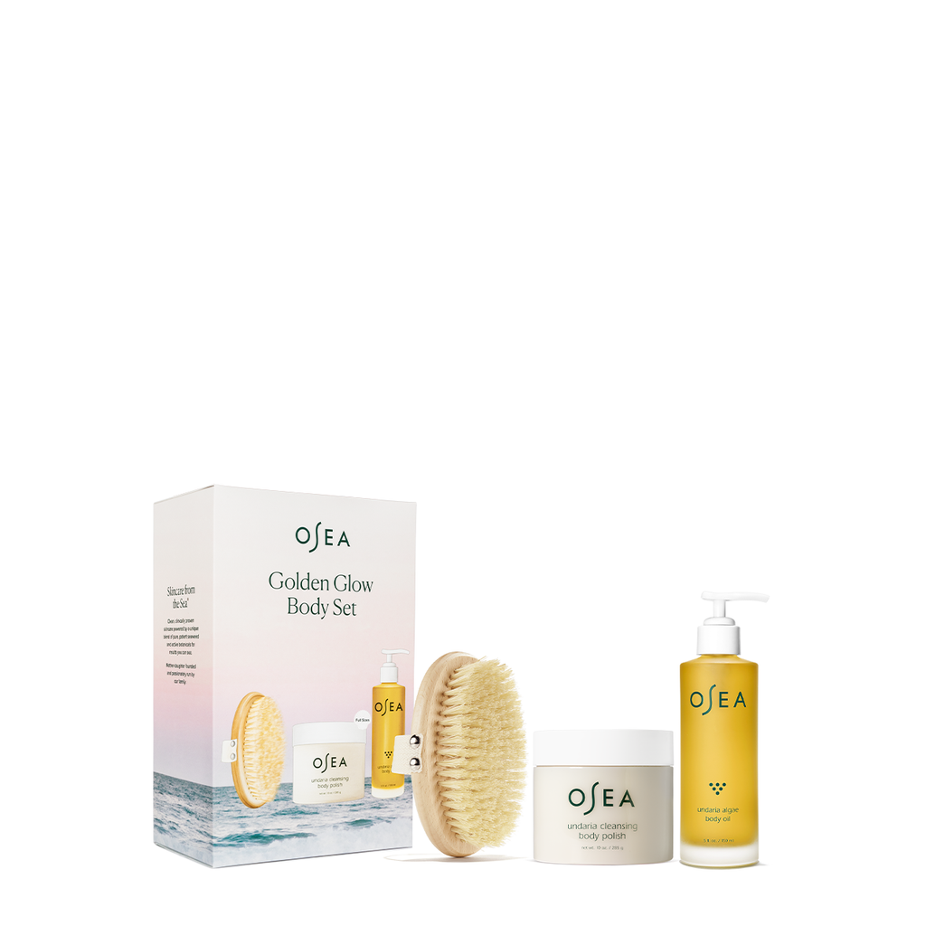 Body care product set with dry brush, scrub, and cream from osea displayed against a white background.