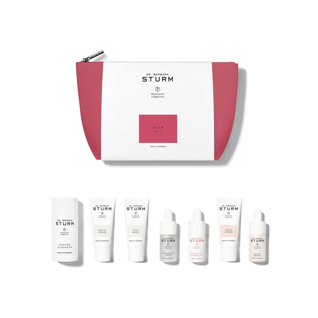 A collection of dr. barbara sturm skincare products displayed with a cosmetics bag.