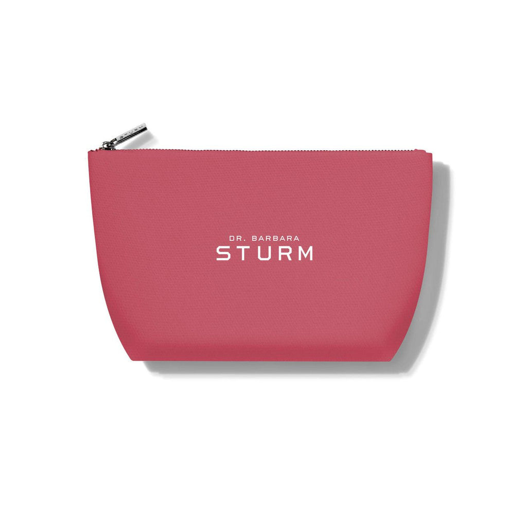 Pink cosmetic pouch with "dr. barbara sturm" branding on a white background.