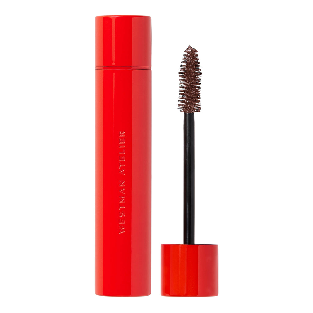 Red mascara tube with applicator wand and brown mascara product visible.