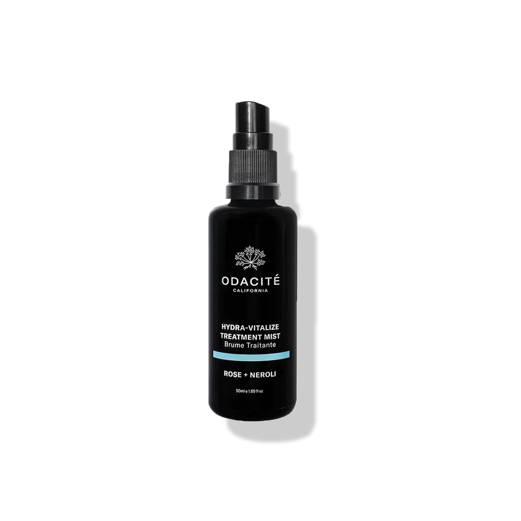 Black bottle of odacite hydra-vitalizing treatment mist with rose and neroli on a dark background.