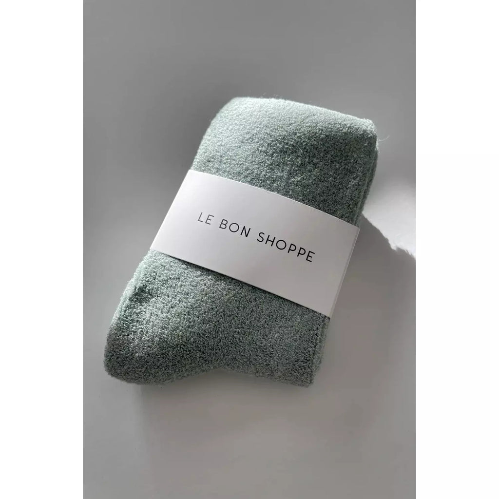Folded green towel with a paper band labeled "le bon shoppe.