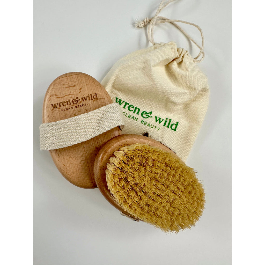 A dry brush with a wooden handle alongside a branded cotton storage bag on a white background.