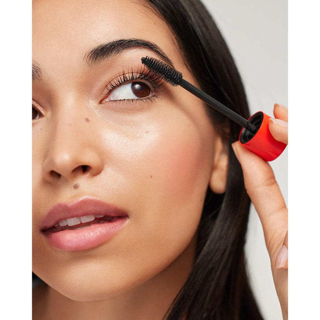 A person applying mascara to their eyelashes.