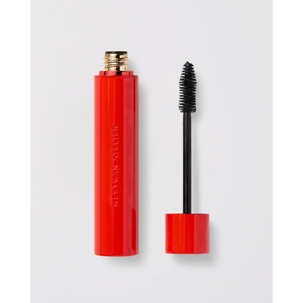 Red mascara tube with applicator brush displayed beside its cap.