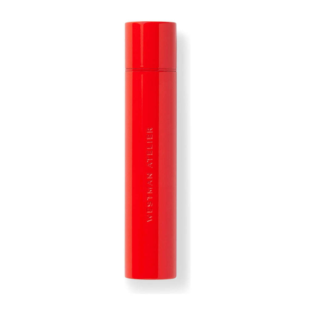 A red westman atelier lipstick tube on a white background.