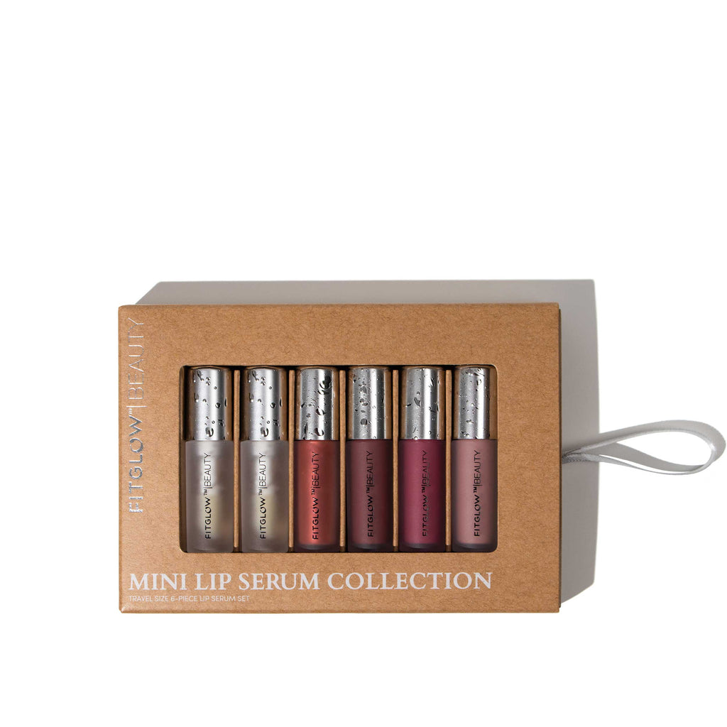 A boxed set of six mini lip serums in various colors, labeled "Fitglow 6 Shade Mini Lip Serum Collection." The packaging is brown with a clear front showing the products inside. Perfect for any occasion, whether you're aiming for a subtle Buff look or an enchanting Beach Glow.