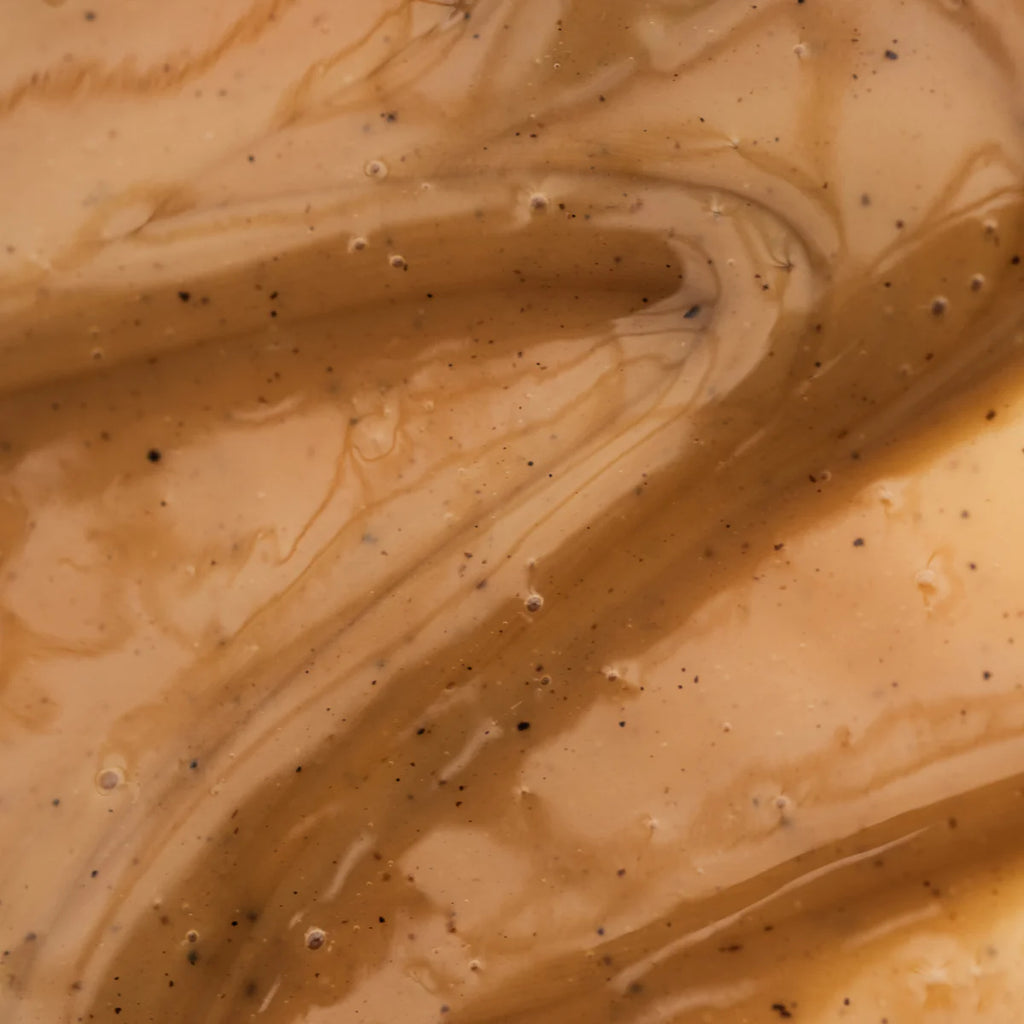 Close-up of swirling coffee with cream, showing a marbled pattern.