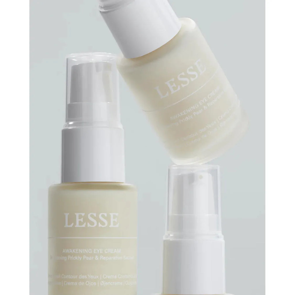 Two skincare bottles against a pastel background, one labeled "lesse awakening eye cream" and the other "lesse regeneration mist.