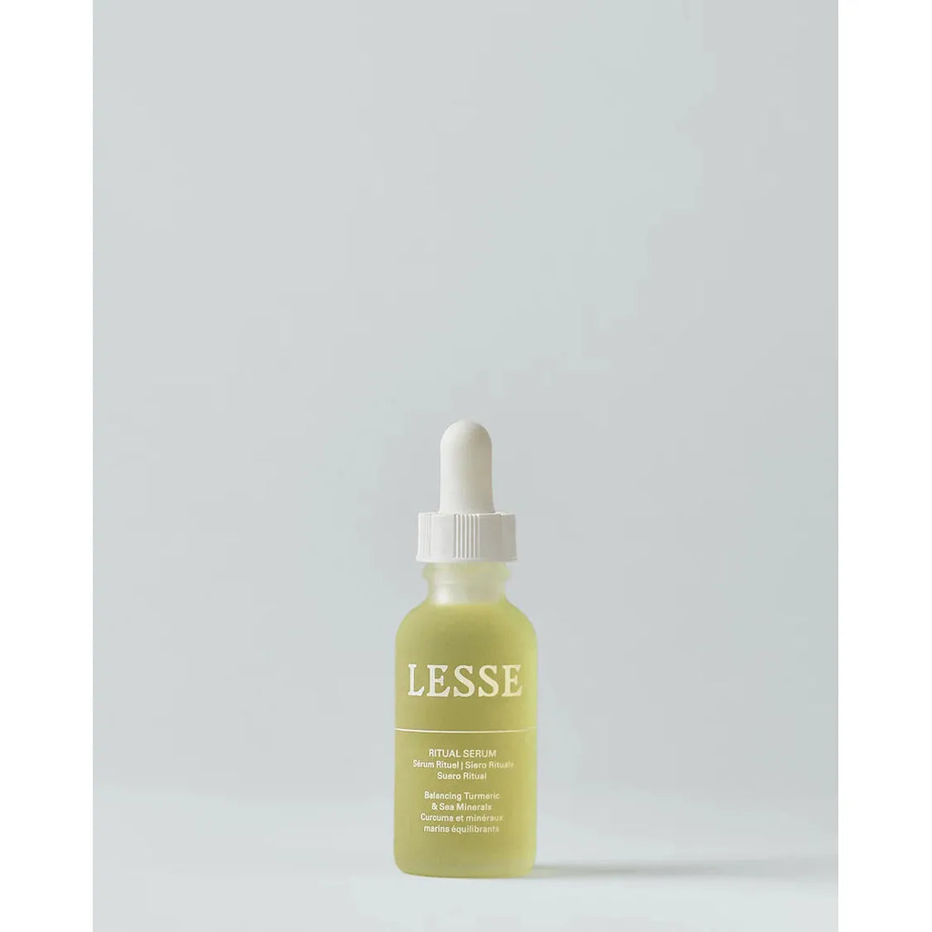 A dropper bottle of lesse ritual serum on a plain background.