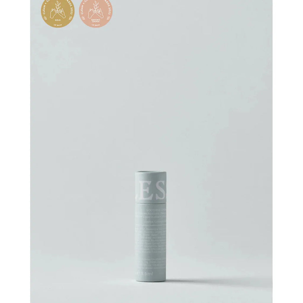 LESSE lip balm with label standing against a plain background, accompanied by award badges in the upper left corner.