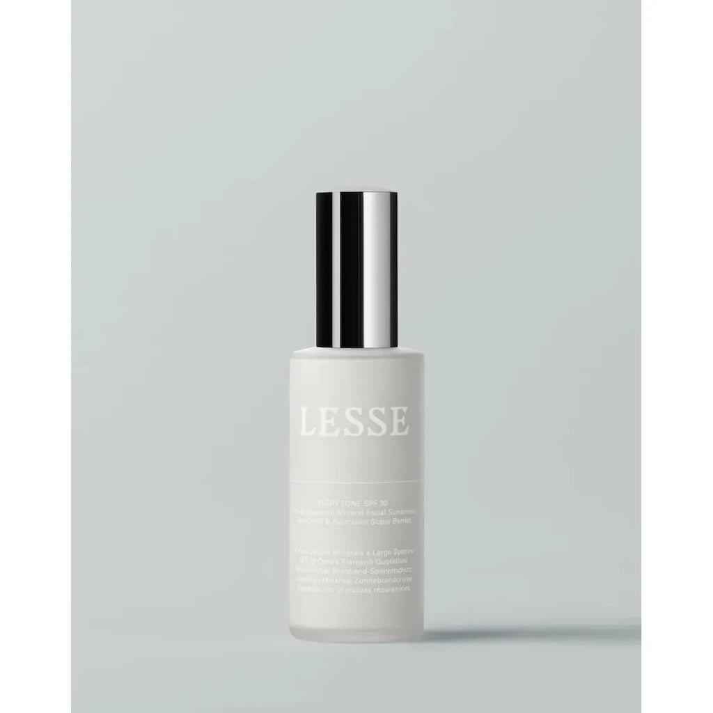 A bottle of lesse skincare product against a plain background.