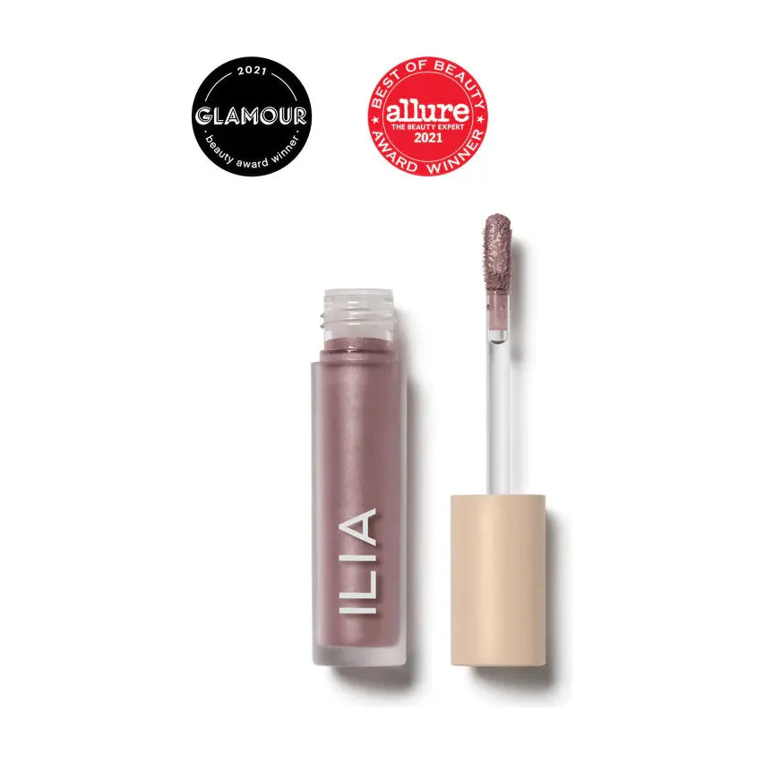 A tube of ilia lip gloss displayed next to its applicator wand, with glamour and allure 'best of beauty' 2021 award badges.