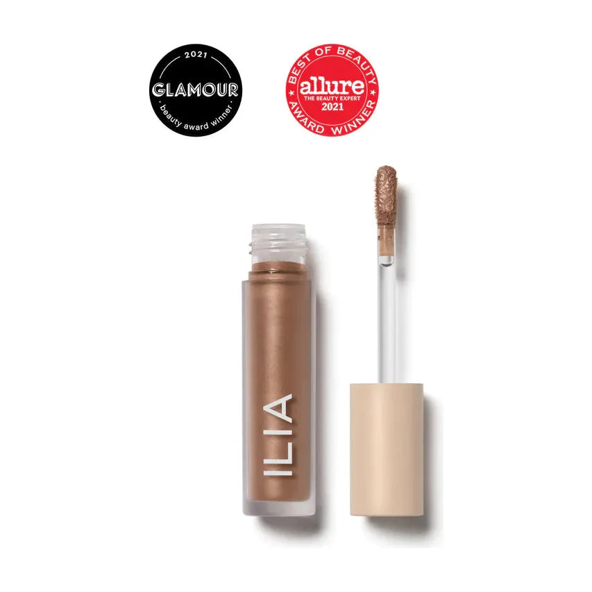 Liquid eyeshadow product with applicator and two award badges.
