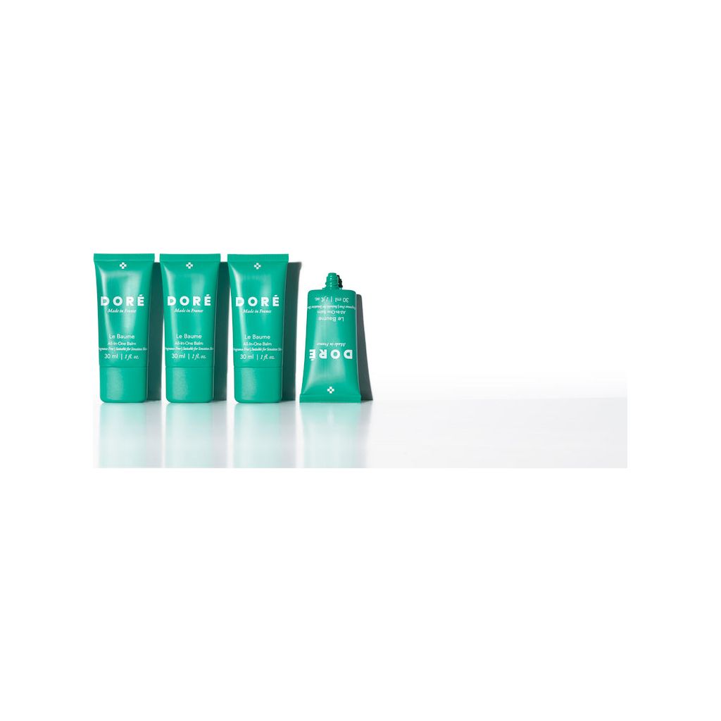 Four green tubes of skincare products arranged in decreasing size from left to right against a white background.