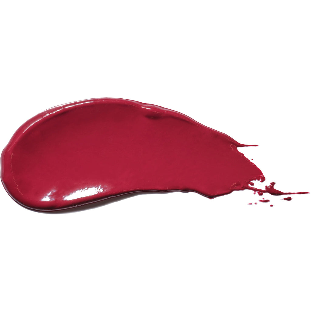 A dollop of red nail polish spilled on a white surface.
