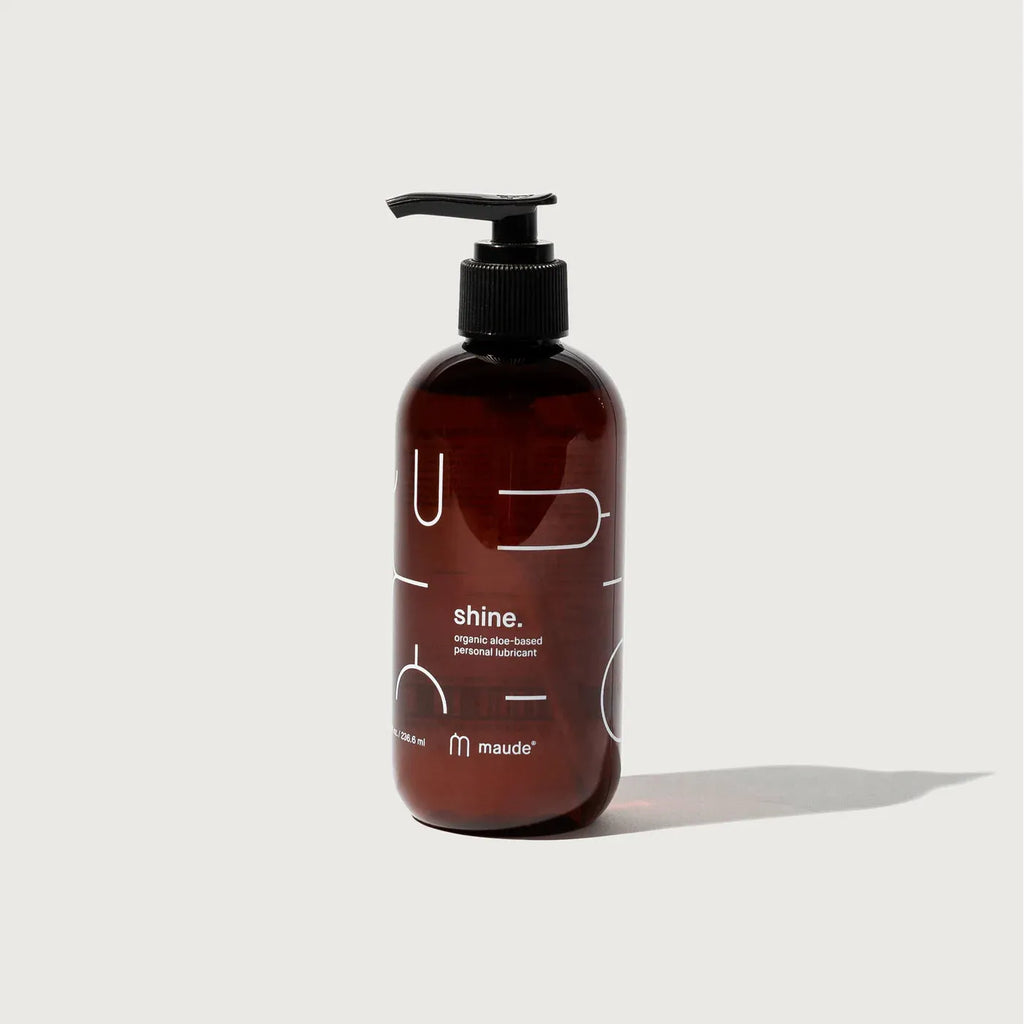 Brown bottle with a pump labeled "shine." by maude, ph neutral, universal wash.