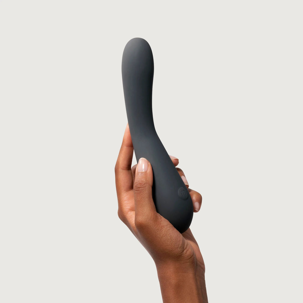 A hand holding a curved personal massager against a white background.