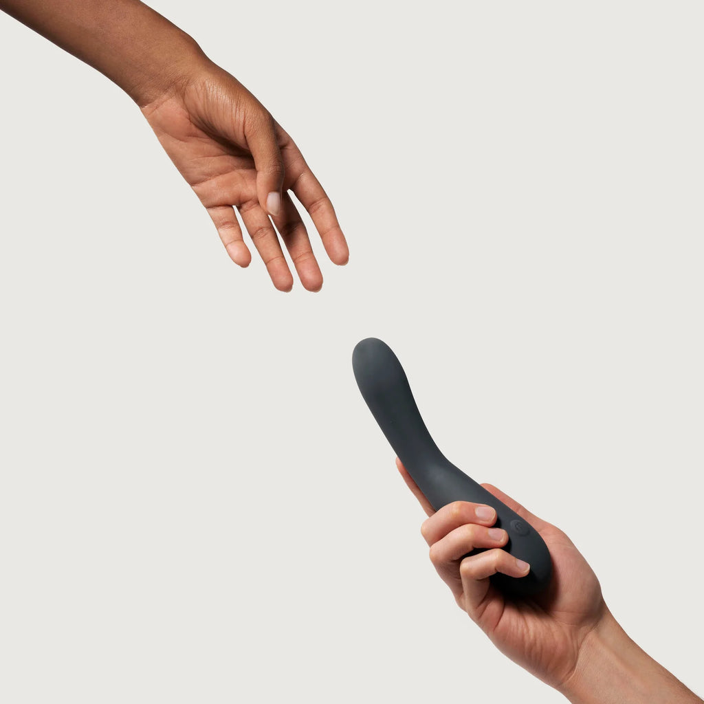 Two hands approaching each other, one holding a curved object.