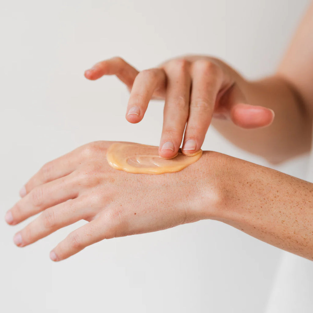 Applying liquid foundation makeup to the back of a hand.