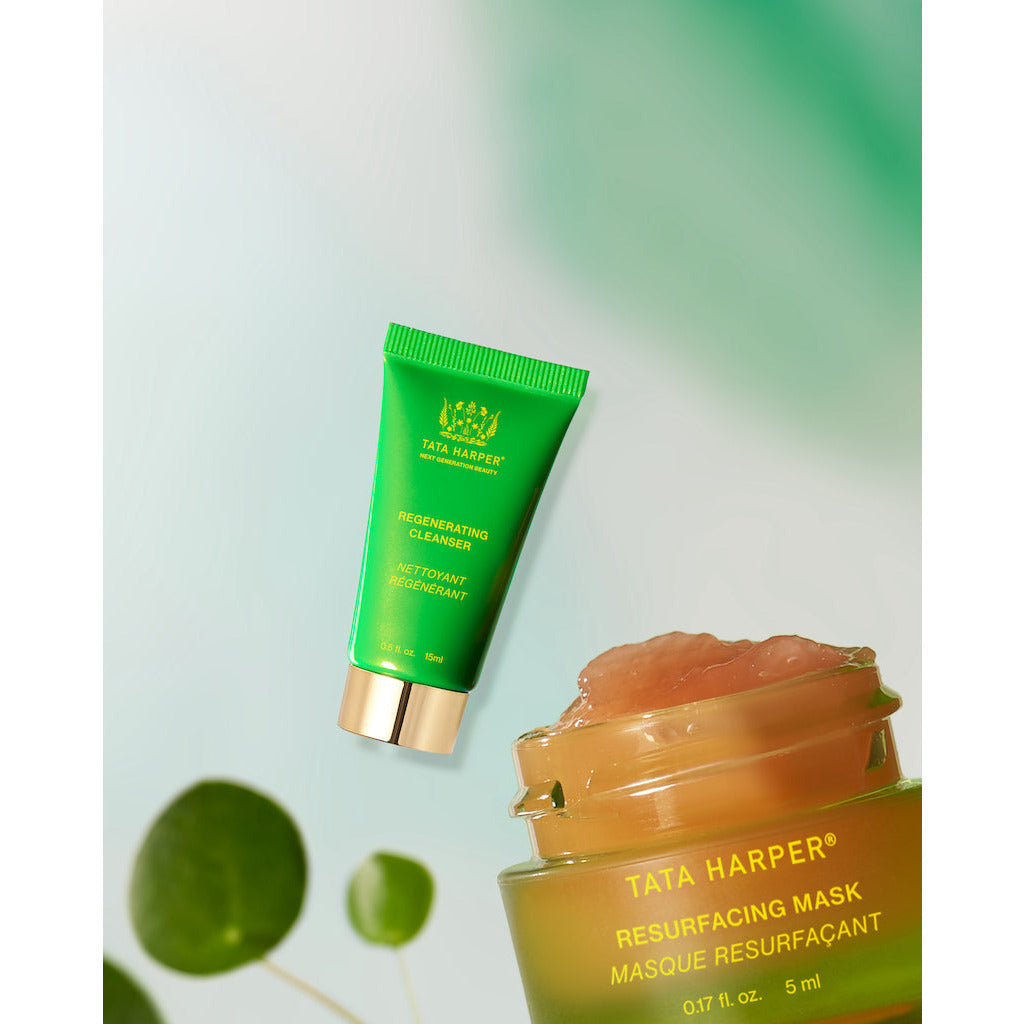 A tata harper resurfacing mask product with a green tube and a portion of its contents artistically displayed on the lid against a light green background.