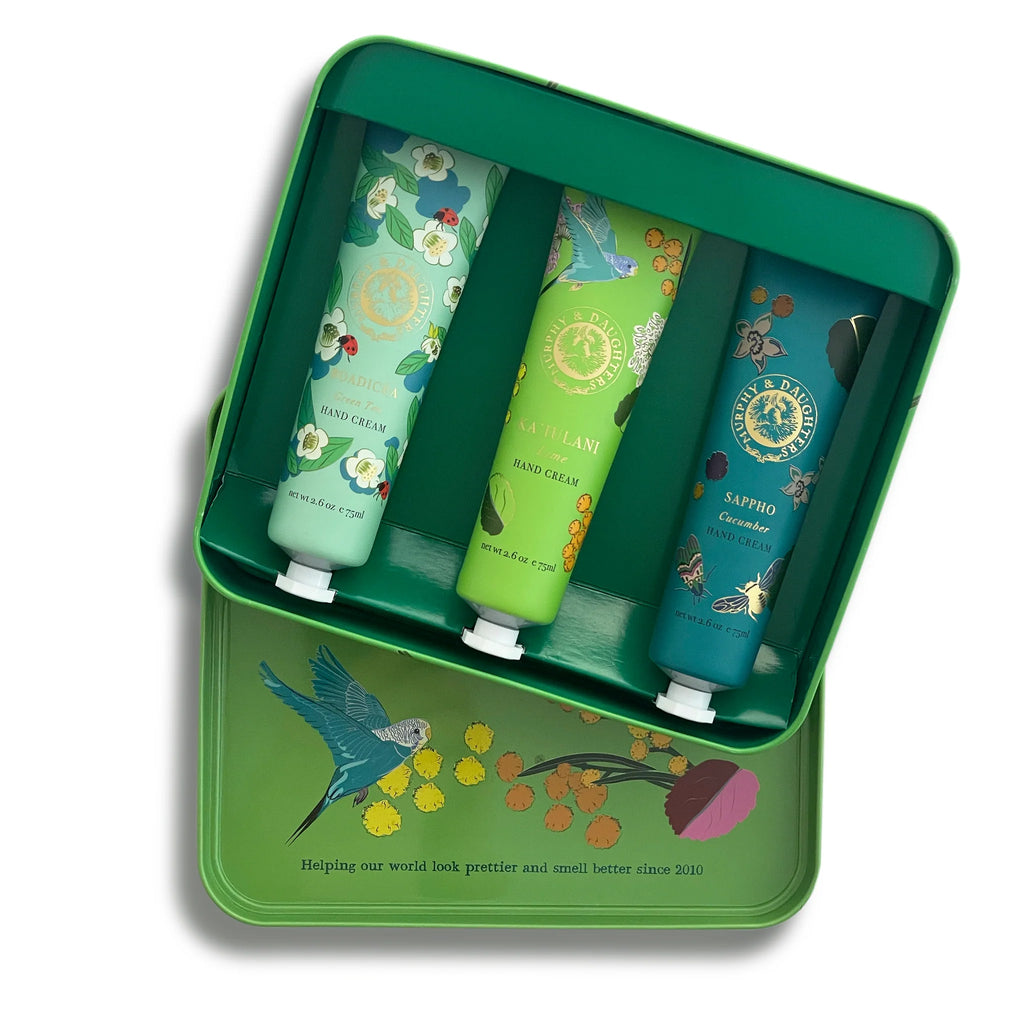 A set of three floral-patterned hand creams in a decorative green tin box.