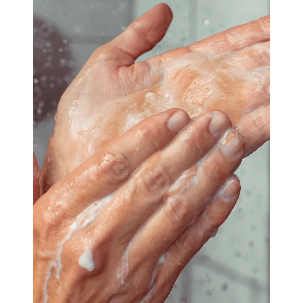 A person lathering hands with soap and water.