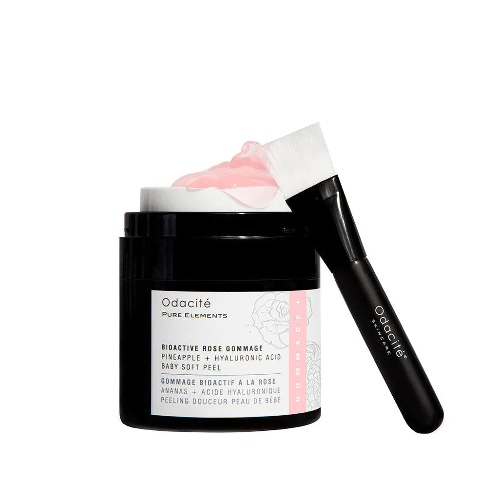 A jar of odacite bioactive rose gommage facial peel with an application brush resting on its lid.