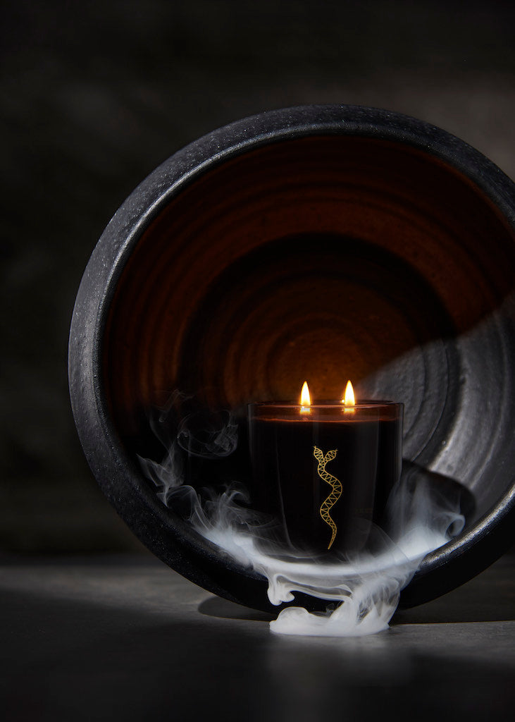 Black candle with a gold design on a dark background