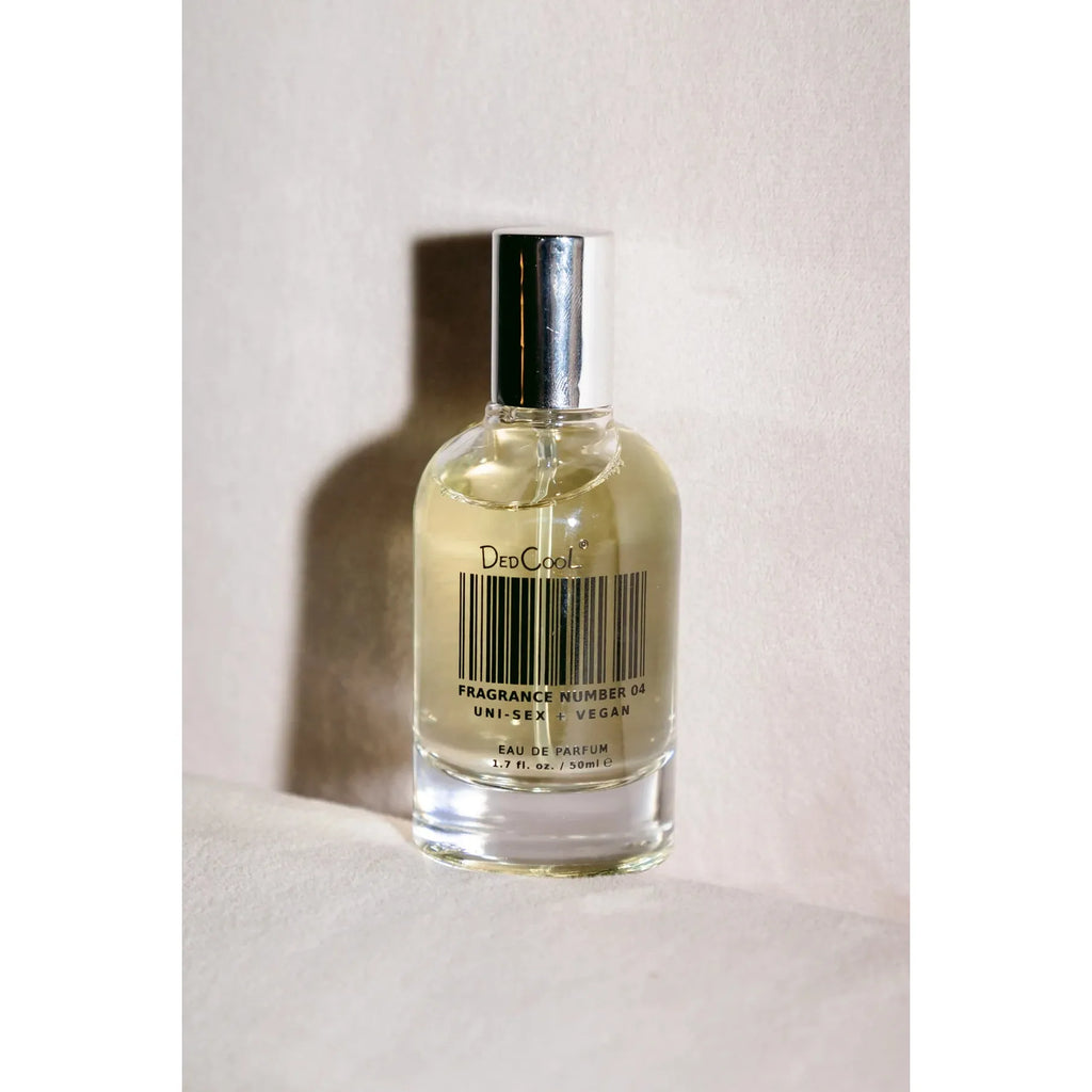 A bottle of perfume casting a shadow on a textured background.