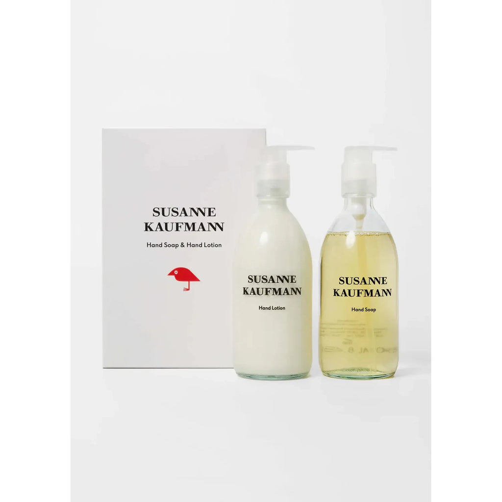 Two bottles, part of the Susanne Kaufmann Hand Soap & Hand Lotion Set, stand in front of a box with the same branding.