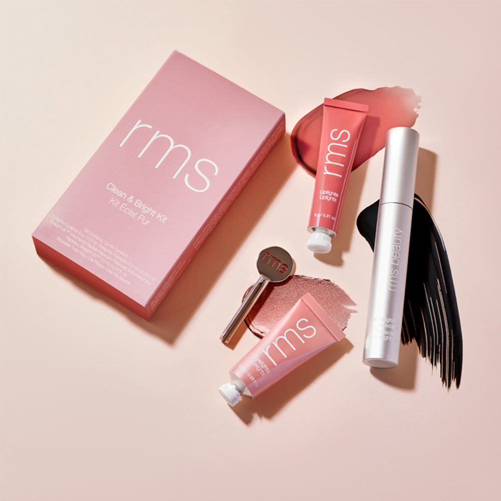 Cosmetic products from rms beauty arranged neatly against a pink background.