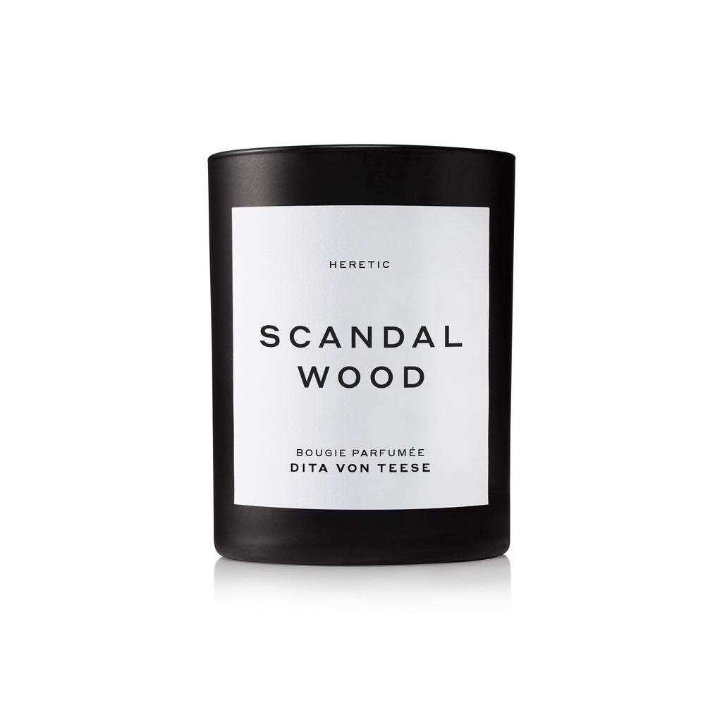 Black scented candle labeled "scandal wood bougie parfumee dita von teese" by heretic on a white background.
