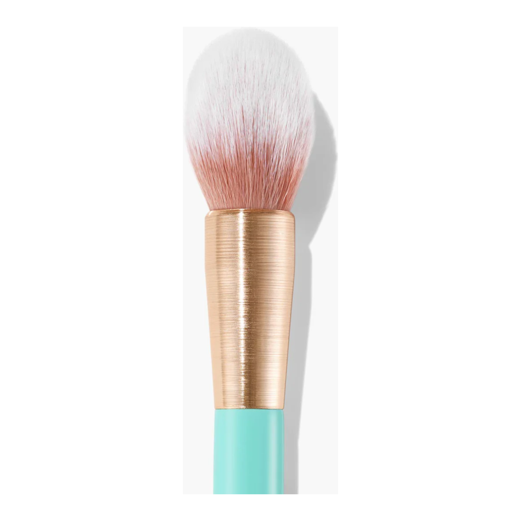Cosmetic brush with a gold and teal handle and white bristles with pink tips on a white background.