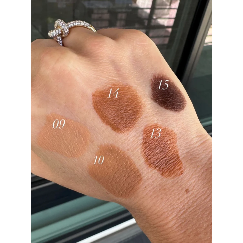 Swatches of four brown eyeshadow shades numbered 09, 10, 14, and 15 on a person's wrist.